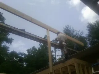 Carpenter setting a ridge beam over a new addition frame — Ice Dam Removal by Roofing Brothers in North Chatham