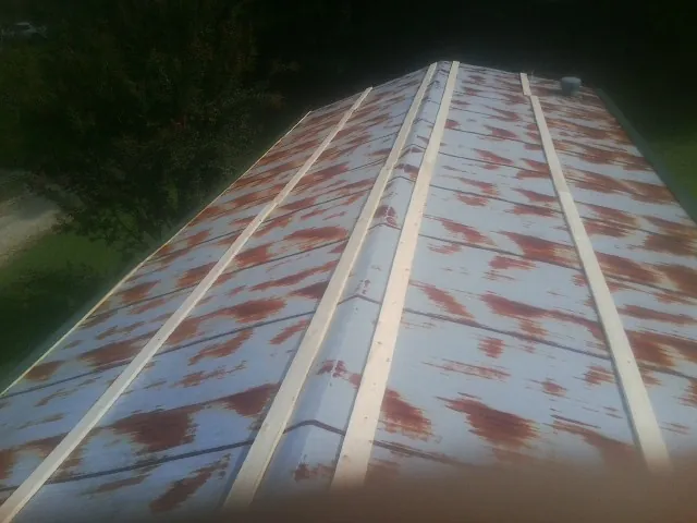 Rusted metal roof panels with new wood purlins before replacement — Storm Damage Roof Repair in North Chatham by Roofing Brothers