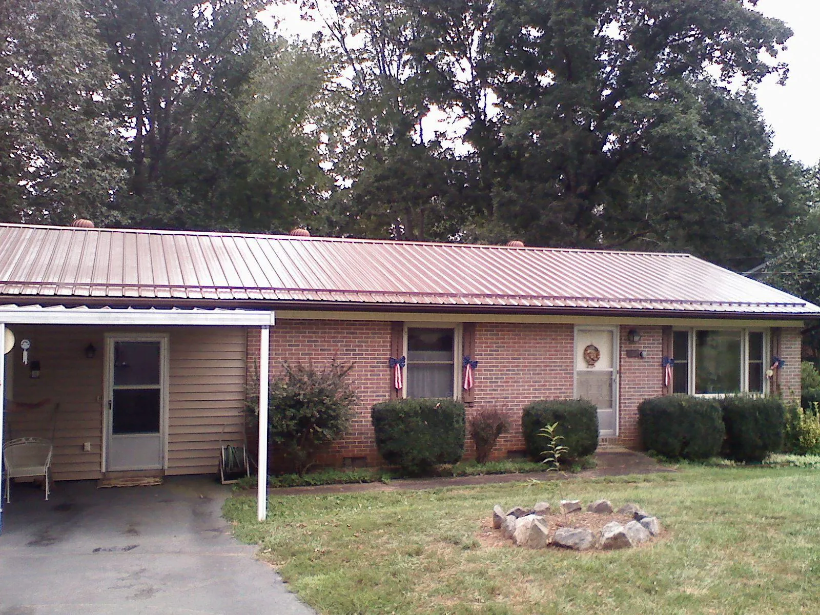 Bronze metal roof and carport on a brick ranch home — Roof Repair work by our crew in North Chatham